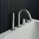 Wannenrandarmatur von Ideal Standard mit einem umschaltbaren Auslauf, einer Handbrause und einem Bedienelement, montiert an einer weißen Badewanne vor schwarzer Fliesenwand.